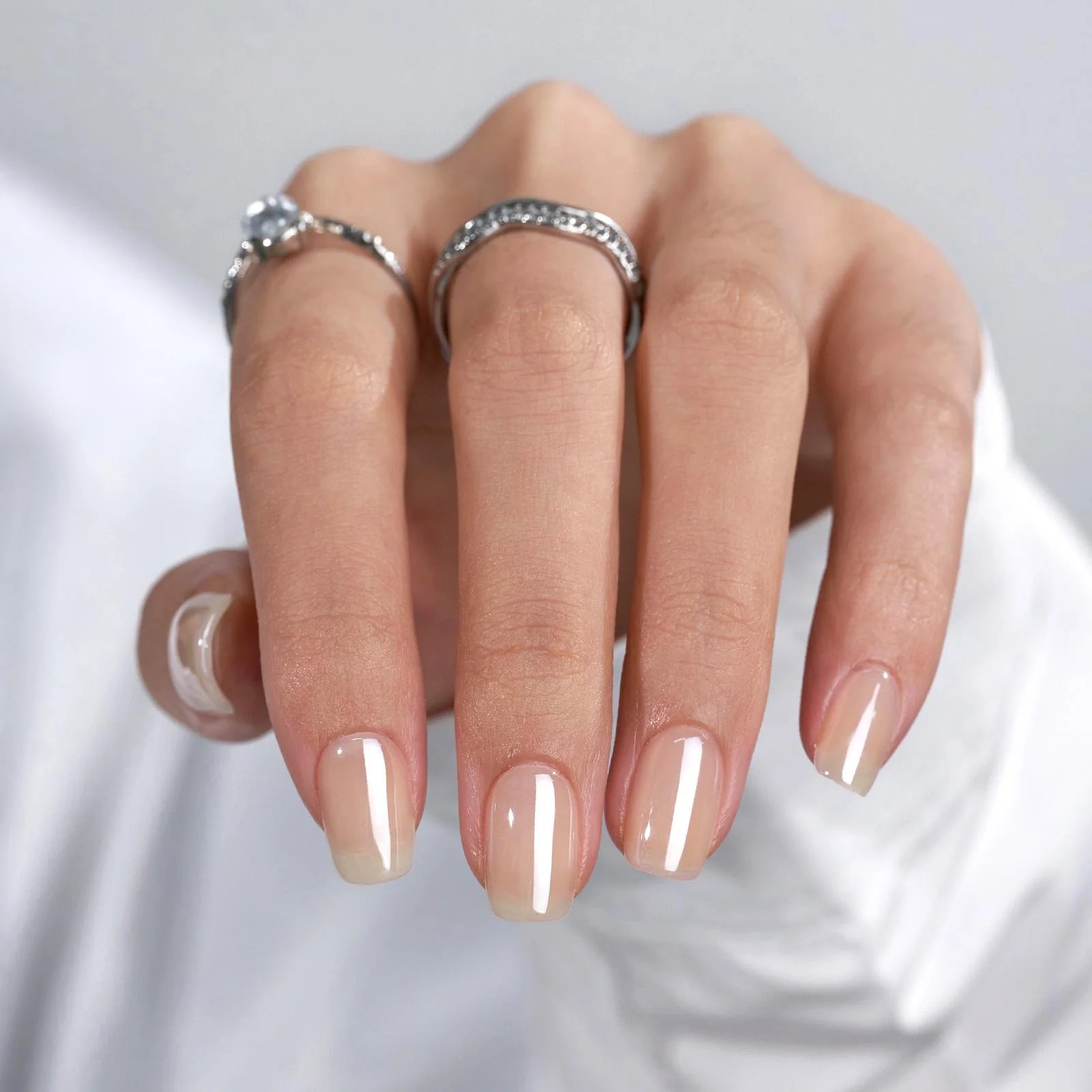 Heavenly Halo press-on naglar styling – korta square nude-naglar med silverringar mot vit blus