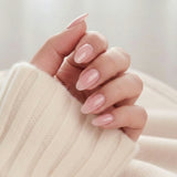 Pinkie Pearl press-on negle sart rosa pearl i mandelform mod creme strikket trøje