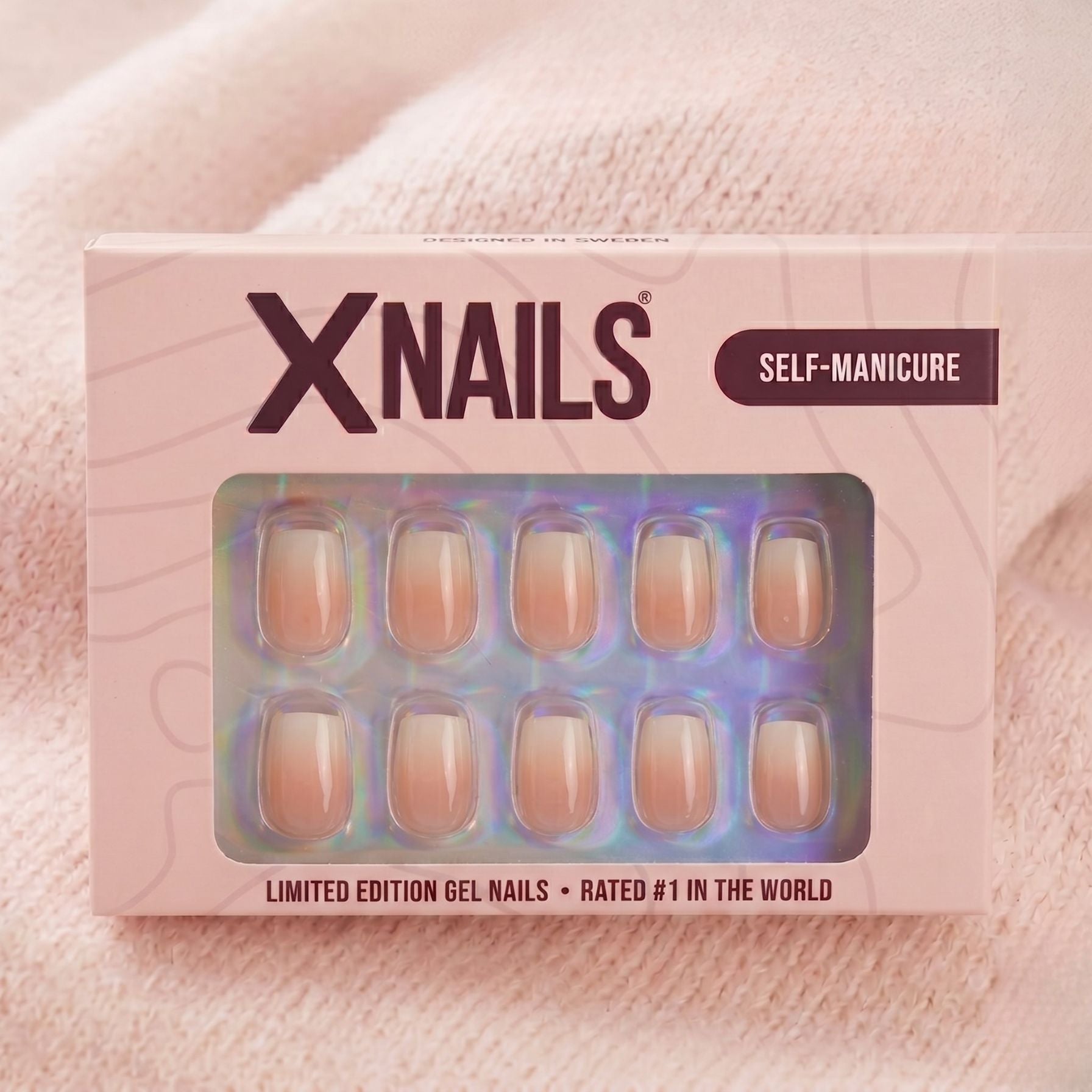 Dreamy Dip XNails æske, limited edition gelenegle i firkantet form med lyserød-hvid ombré mod beige strikket baggrund