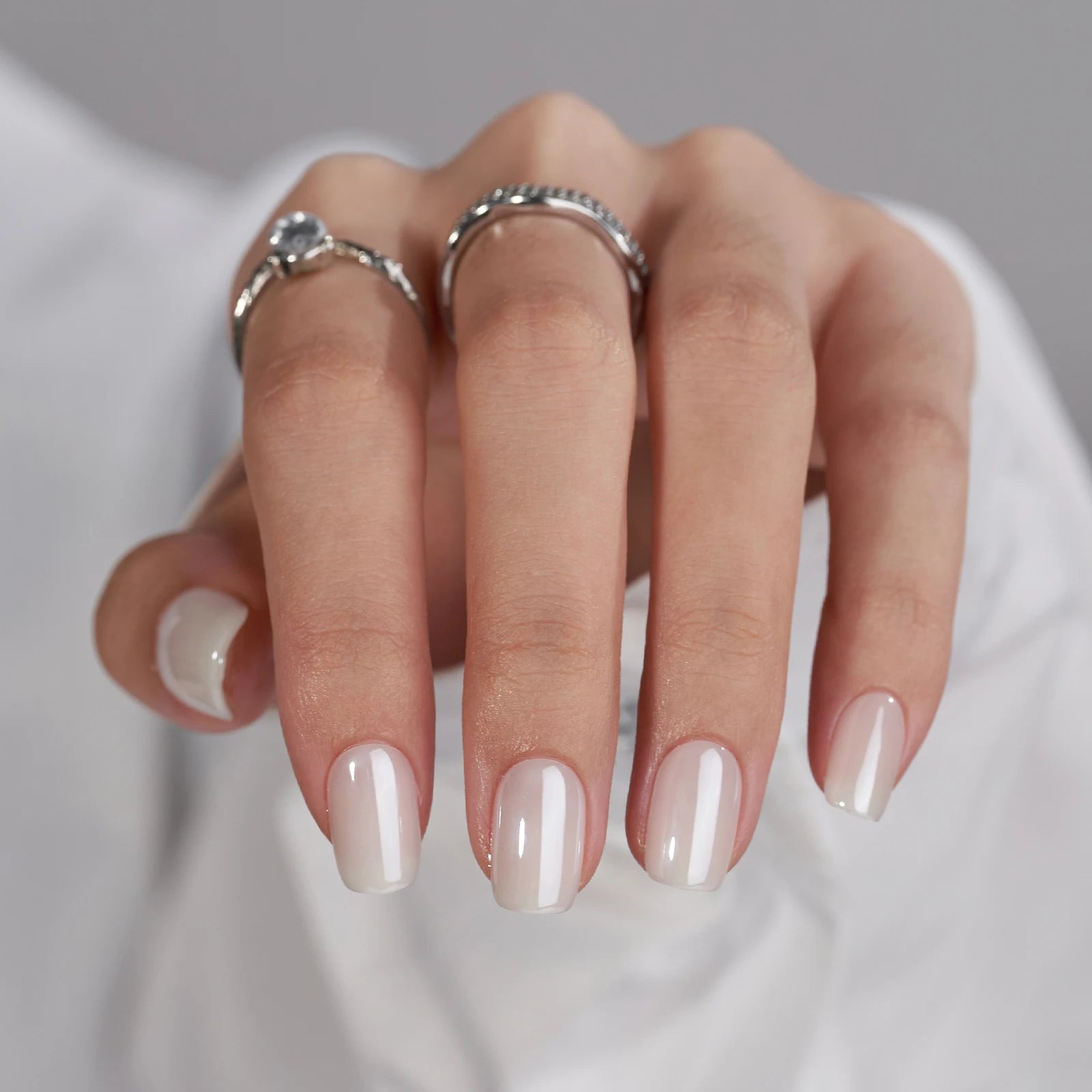 Pure Pearl press-on negle nærbillede: nude pearl glans i firkantet form med sølvringe i diamant
