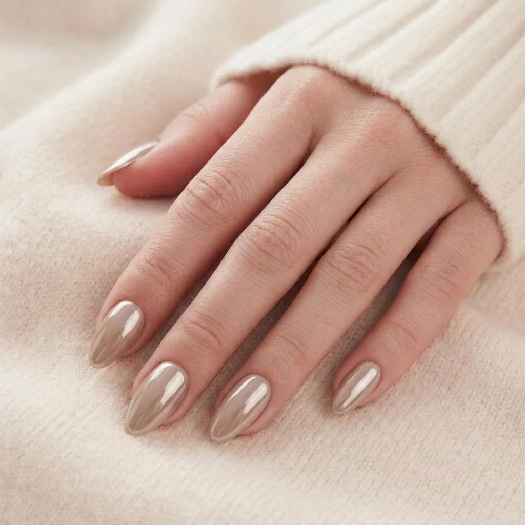 Pearly Perfection negle på hånd mandelformede gelénegle i perlemor taupe hviler mod beige trøje