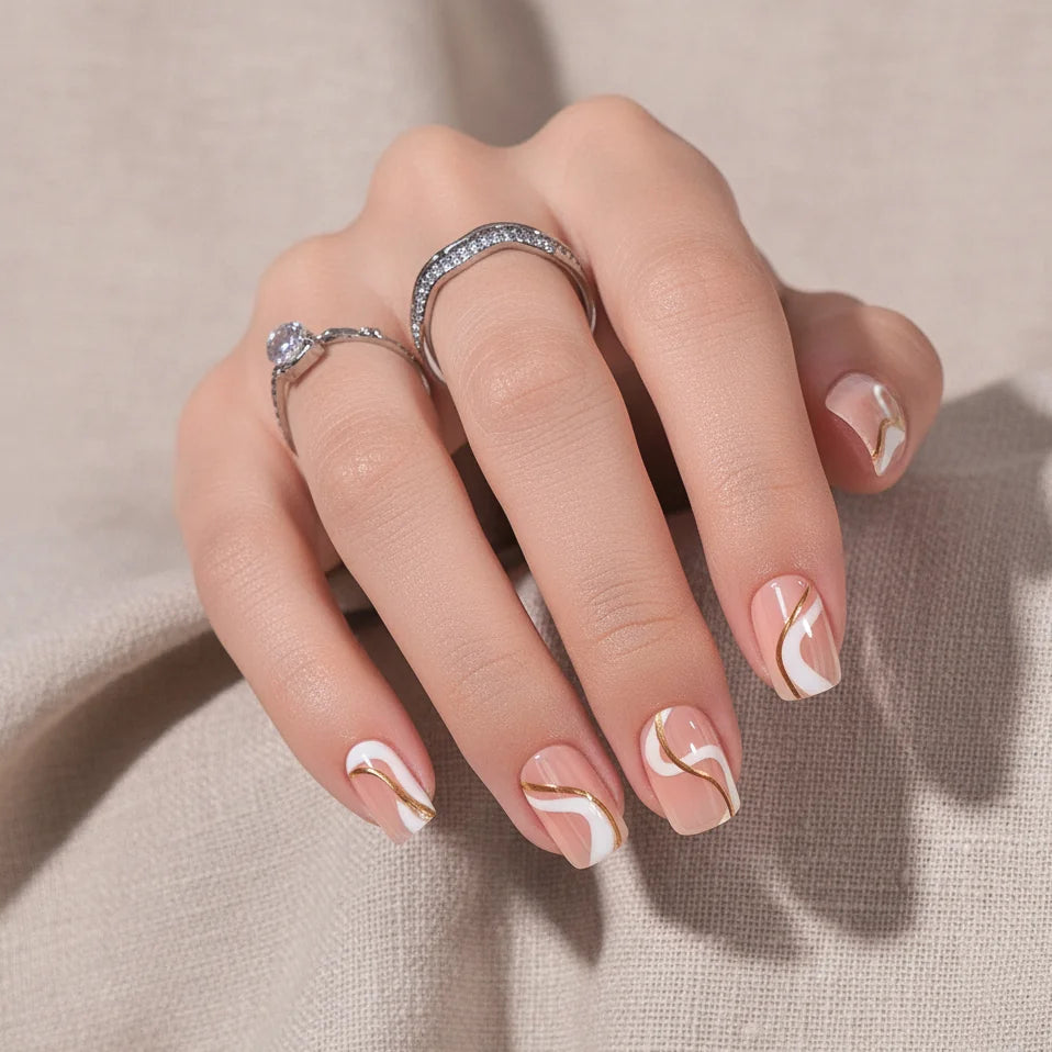 Summer Swirl firkantede press-on negle nærbillede, guld og hvide swirls med sølvringe mod beige hør