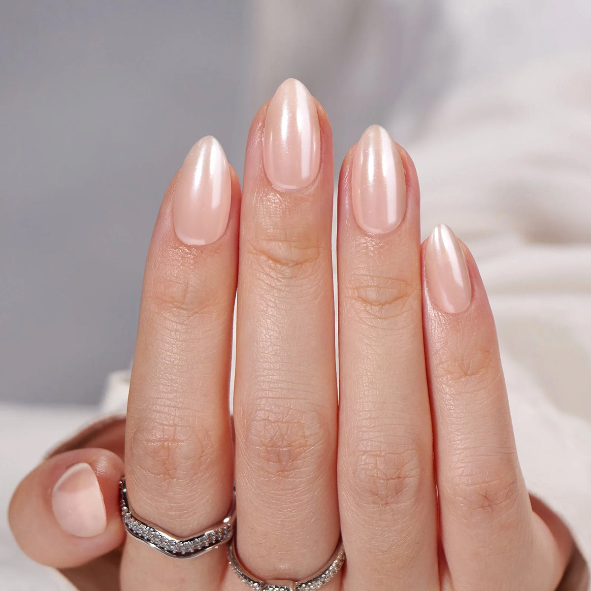 Heavenly Halo gelénegle nærbillede pearl shimmer i mandelform mod hvid satin