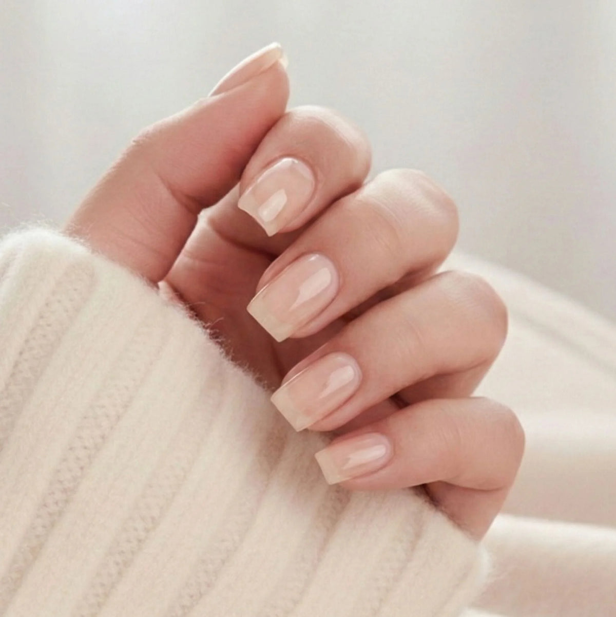 Heavenly Halo press-on negle korte square løsnegle i blød nude med subtilt skimmer mod beige trøje