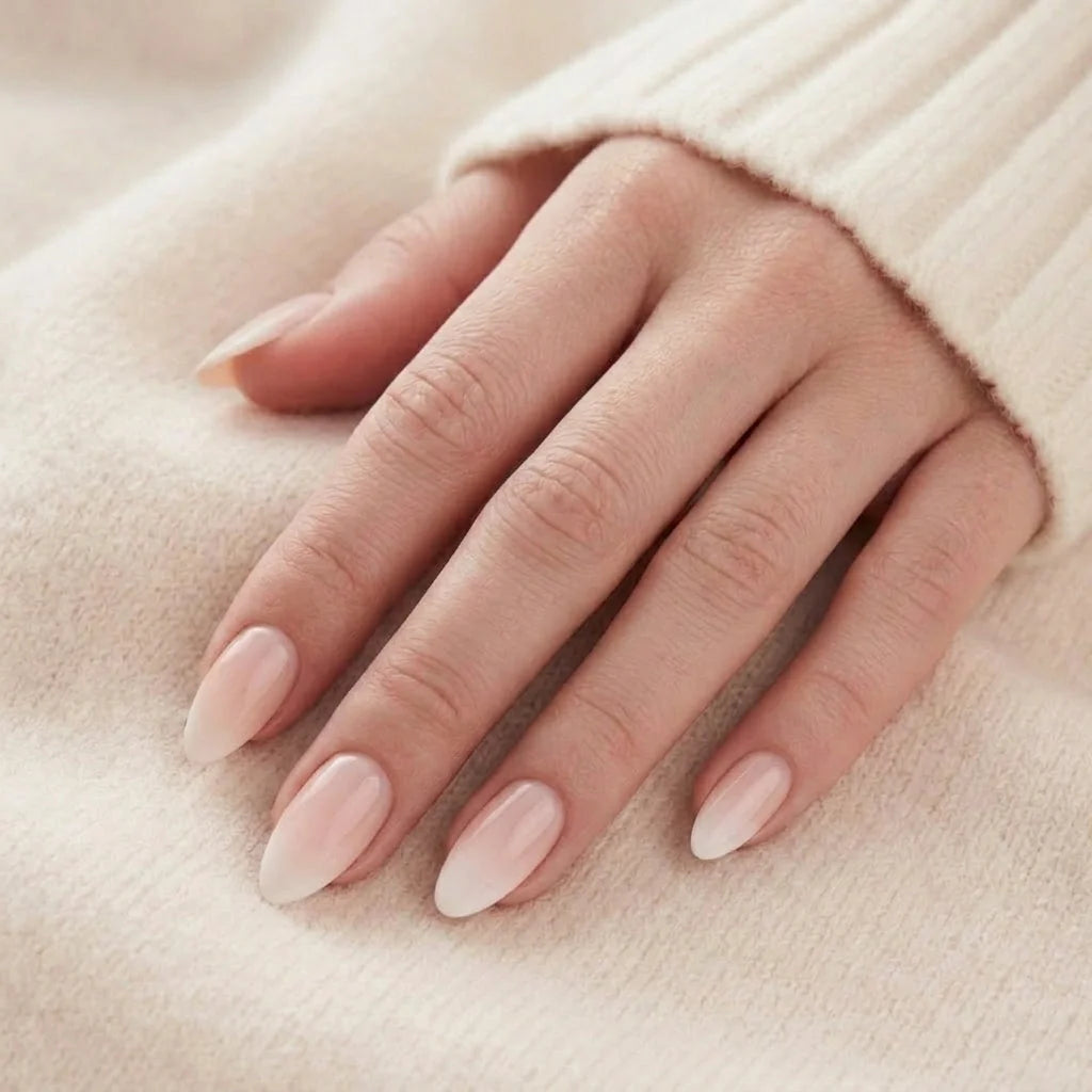 Dreamy Dip negle på hånd, nude lyserød ombre mandelnegle mod beige strikket trøje