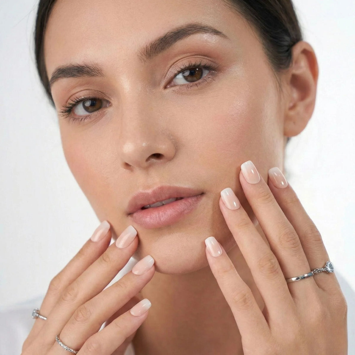 Dreamy Dip Press-on-Nägel Nahaufnahme, Modell hält die Hände am Gesicht mit Ombré Square Nude
