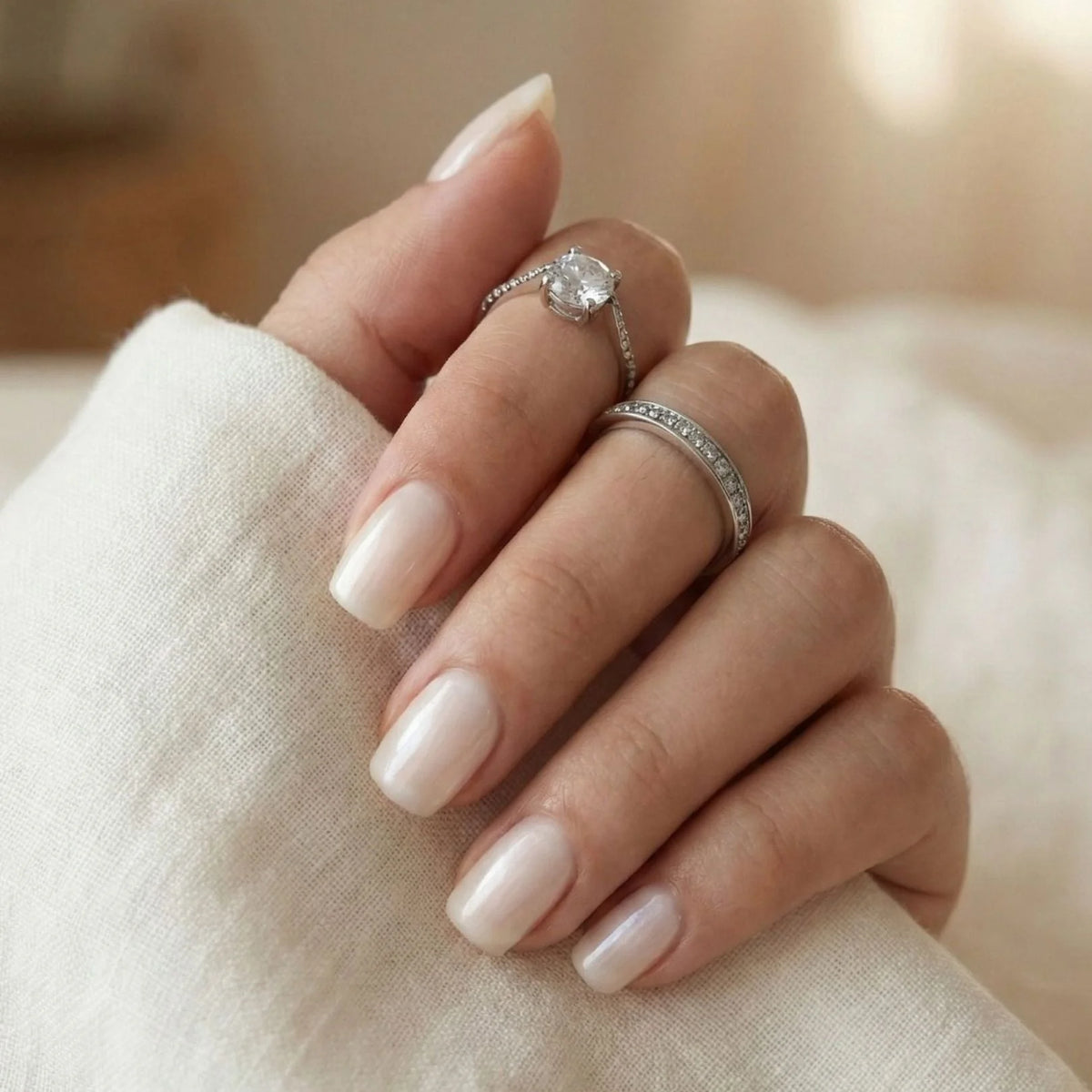 Pure Pearl gelénegle nærbillede kort square i pearl nude med hvid bluse og sølvringe