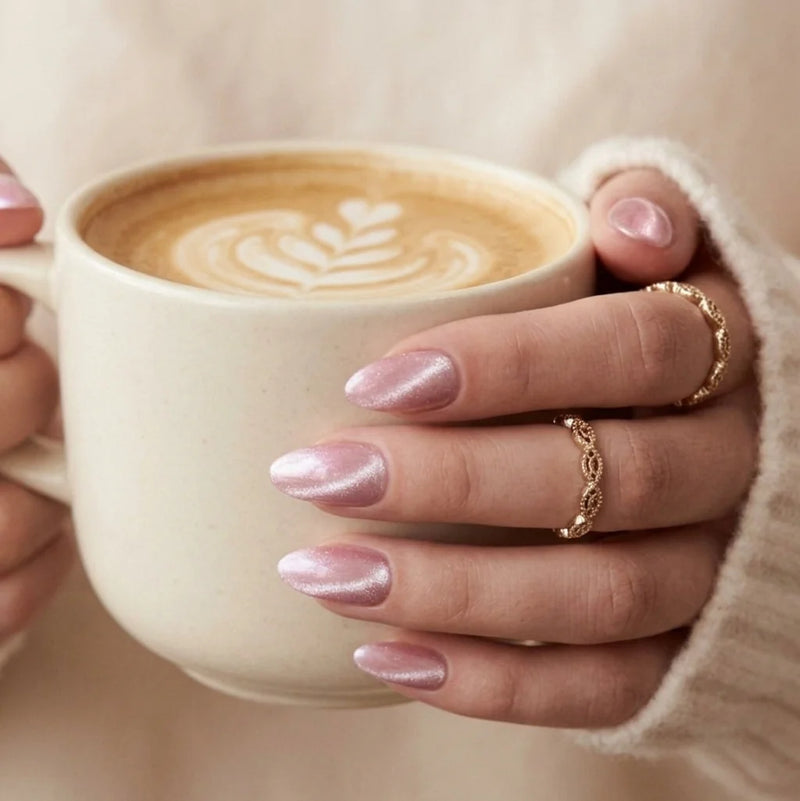 XNails press-on negle på en hånd, der holder en latte, rosa chrome-mandelnegle